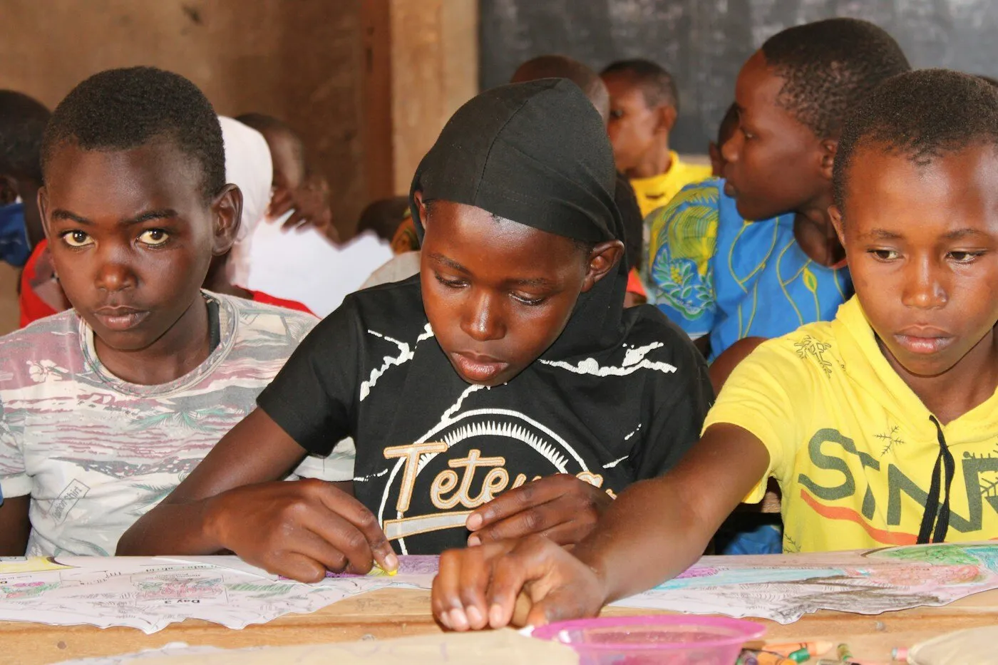 African children sitting together at a table in a classroom in Kenya