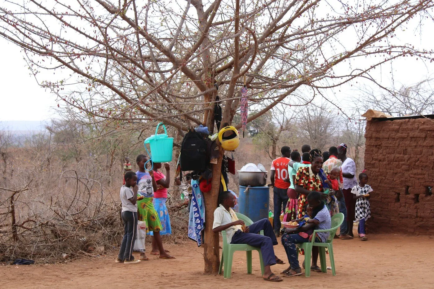 Group of African students standing around a tree outside a school in Kenya