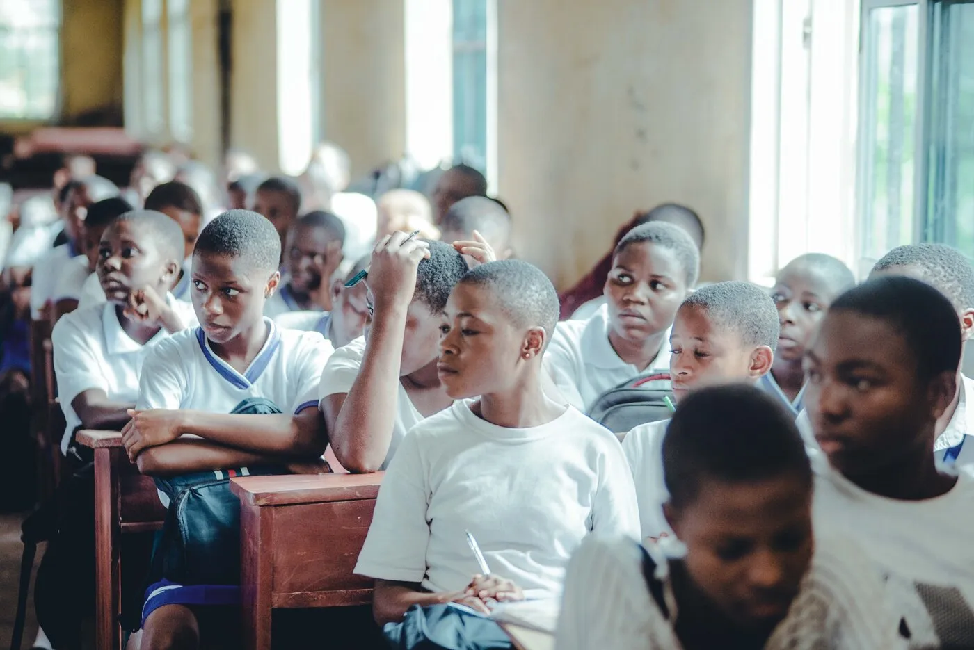 African students in school uniforms attending a classroom lesson