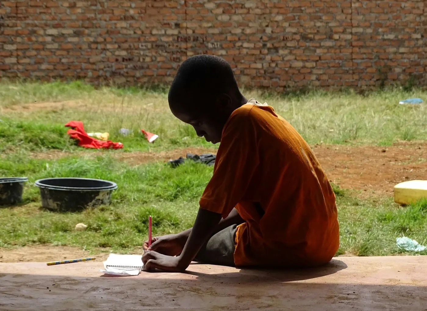 African boy writing on notepad in a classroom
