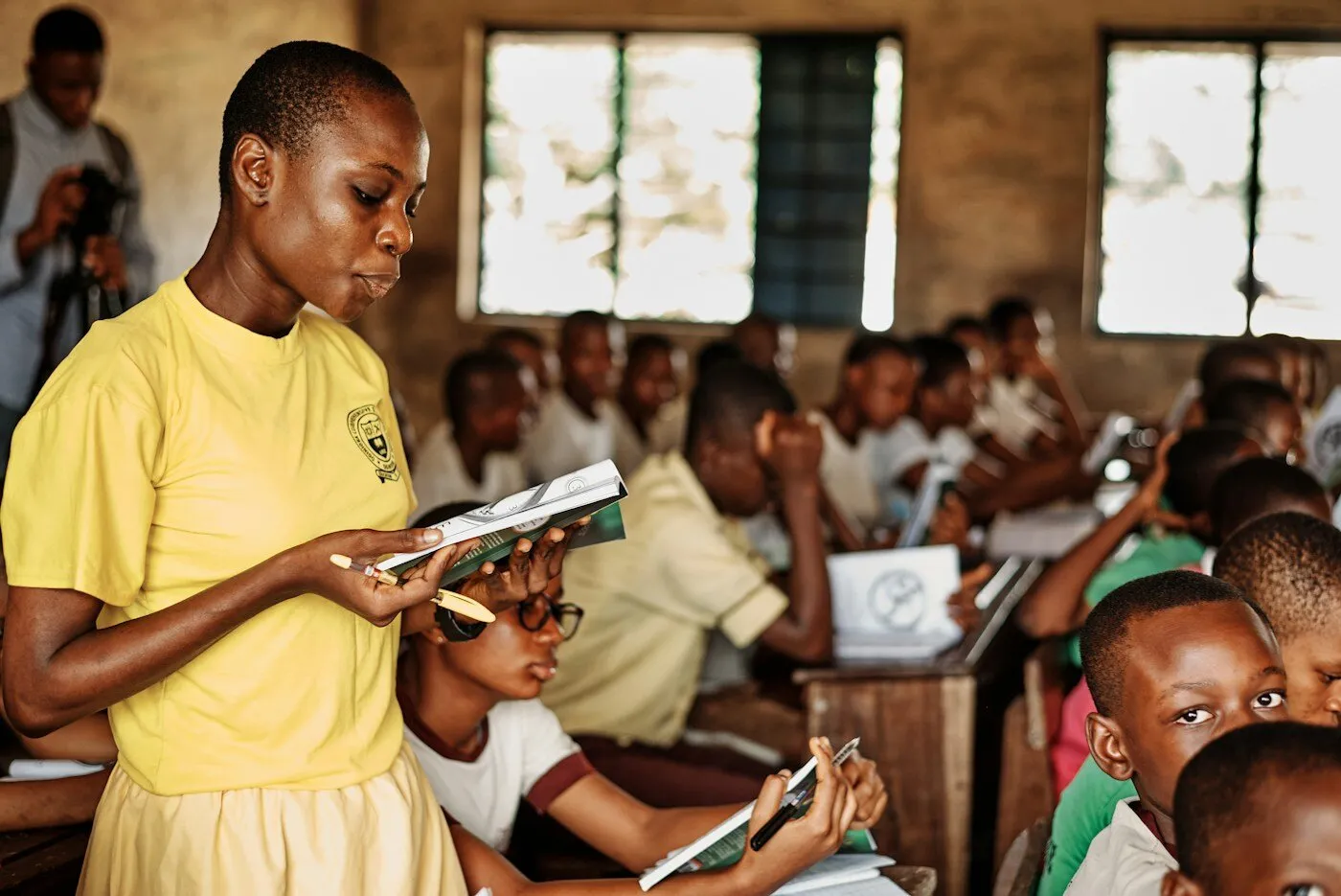 African woman teacher standing in front of children in a classroom