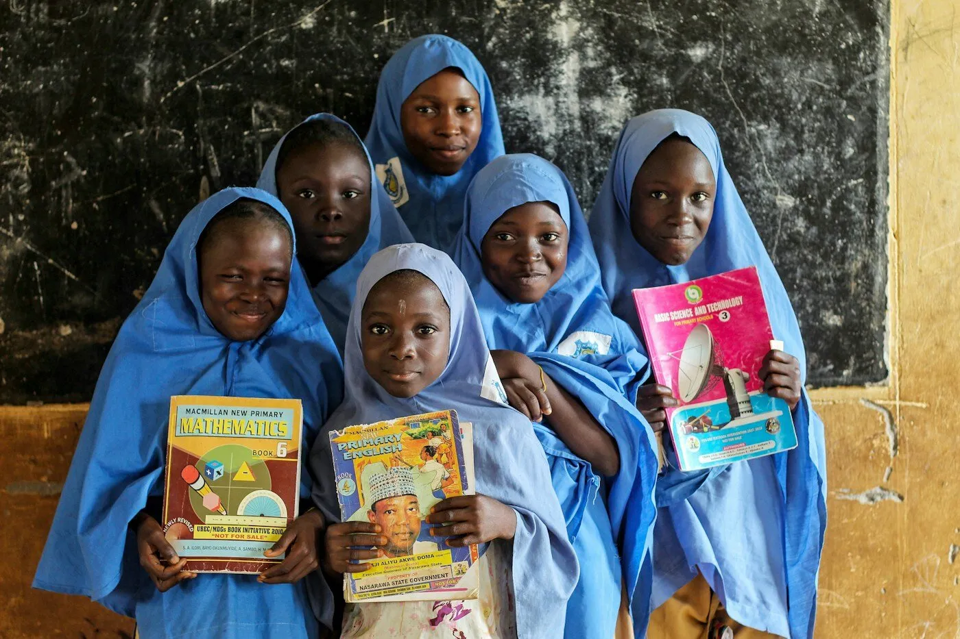 Group of African women holding books and smiling outdoors